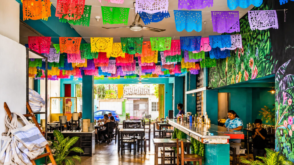 Intérieur d'un restaurant mexicain décoré de guirlandes colorées papel picado sur la Riviera Maya au Mexique.
