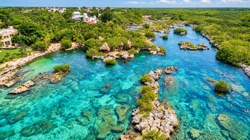 Panorama aérien d'une lagune tropicale de la Riviera Maya, avec ses eaux turquoise, ses îlots rocheux et sa végétation luxuriante.