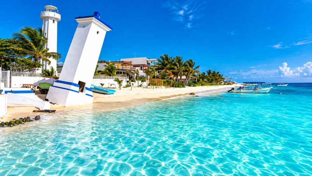 Vue du phare penché de Puerto Morelos, de la plage de sable blanc et des eaux turquoise de la mer des Caraïbes au Mexique.